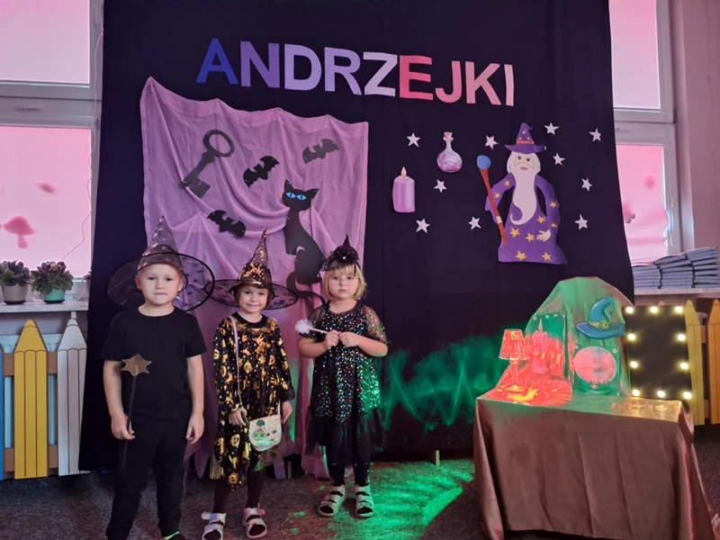 Troje przedszkolaków na tle dekoracji andrzejkowej